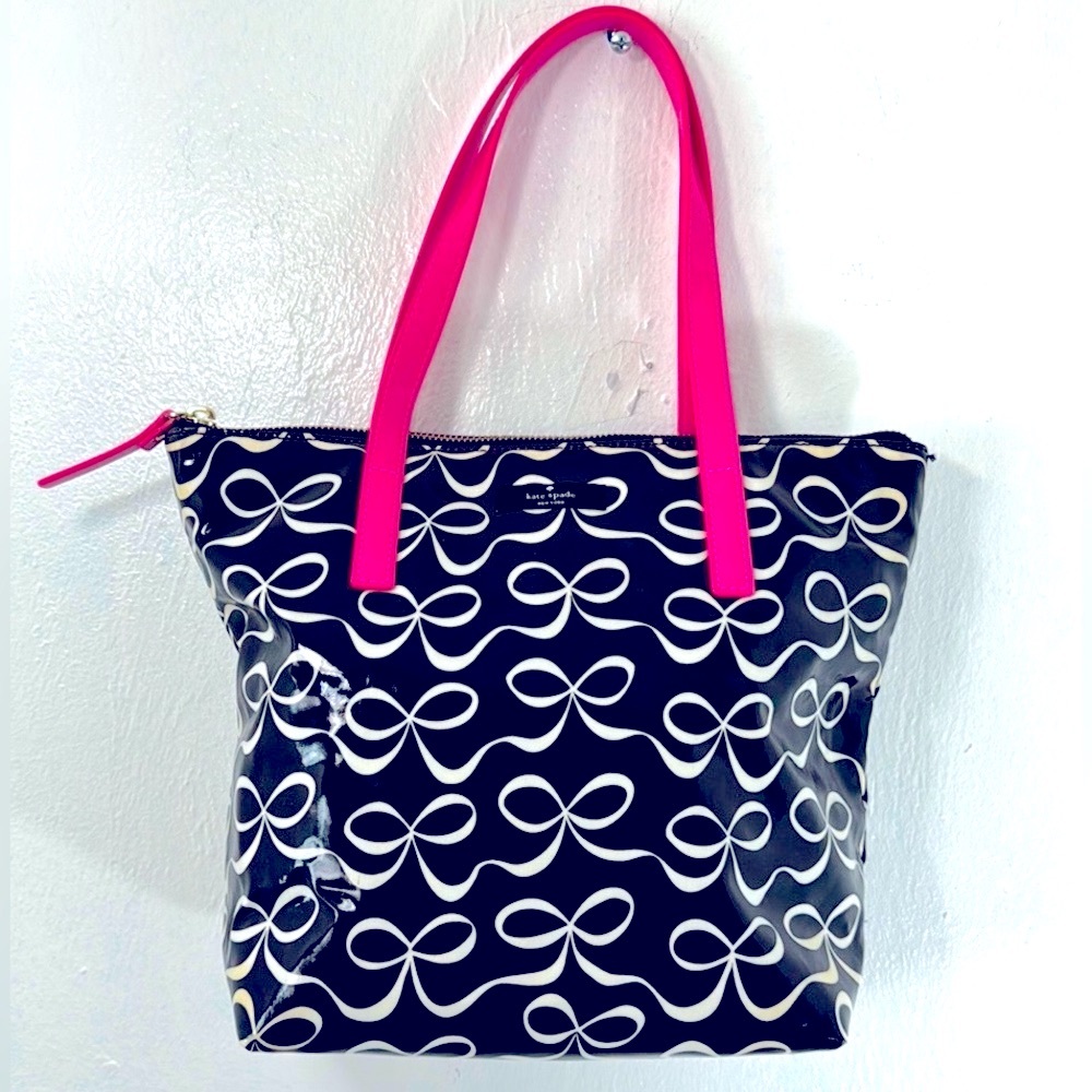 Kate Spade New York- Daycation black tote with white bows and pink handle.